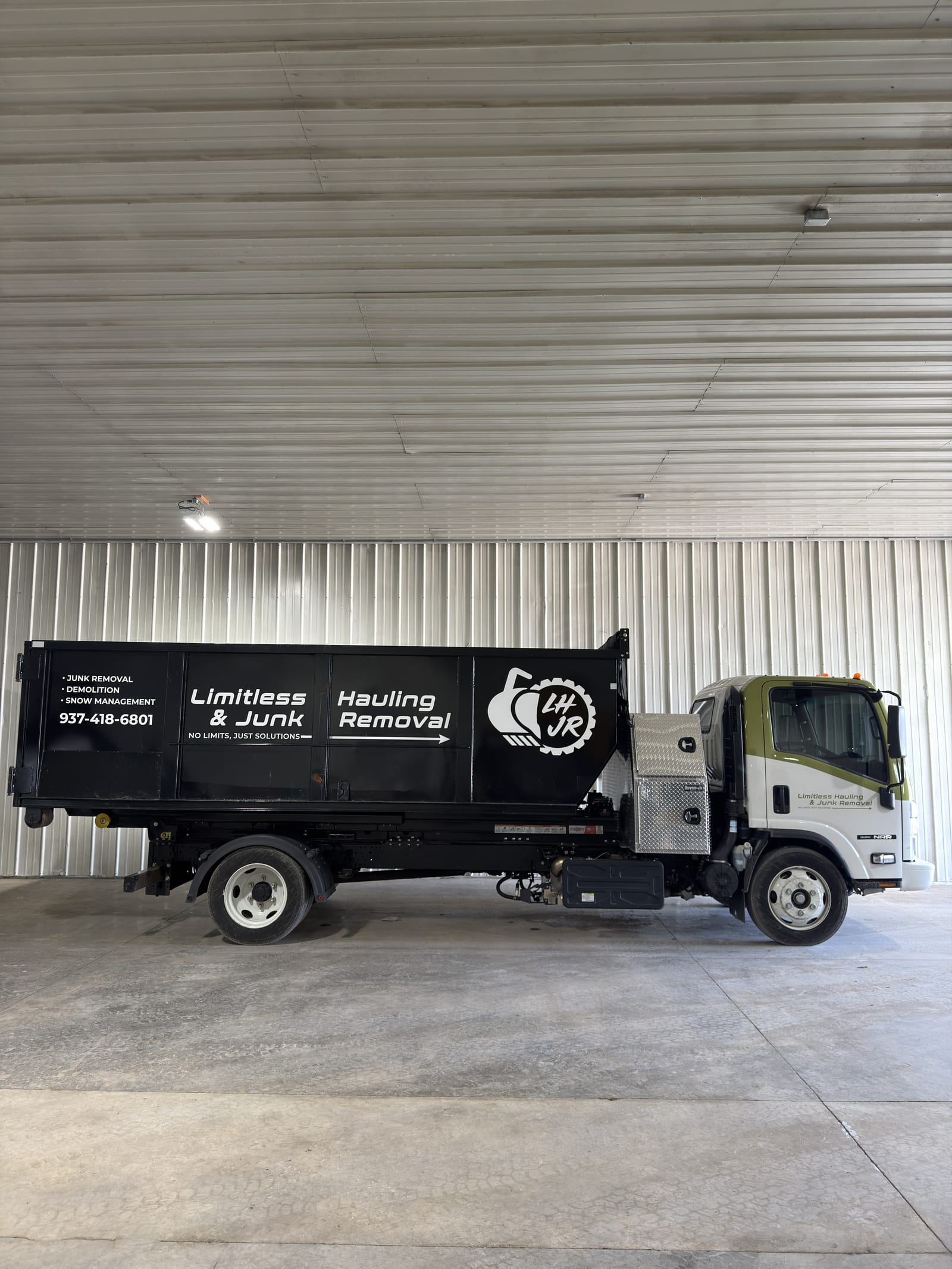A branded Limitless Hauling dump truck in the company shop